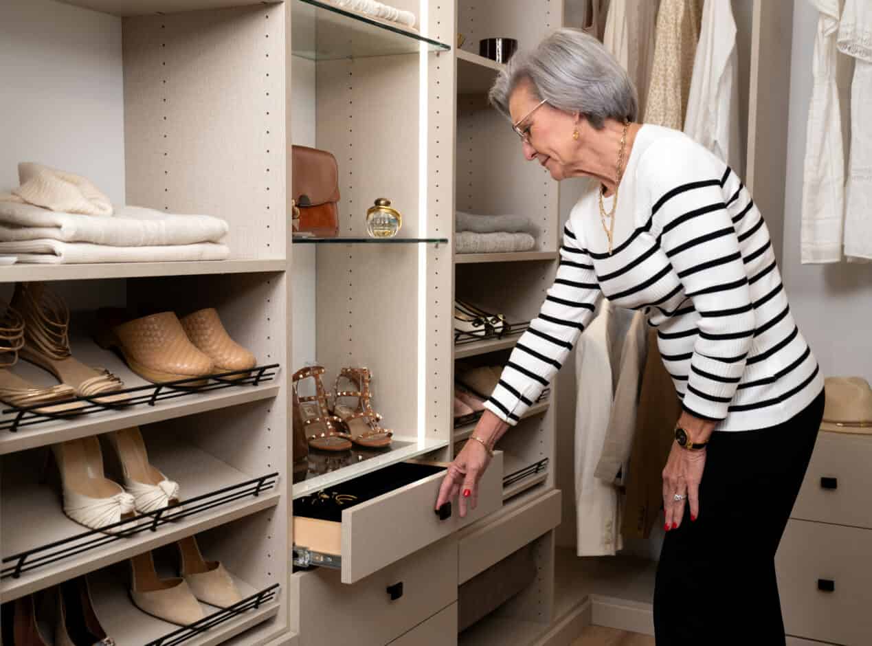 a lady opens a drawer in her custom closet to pick out her accessories